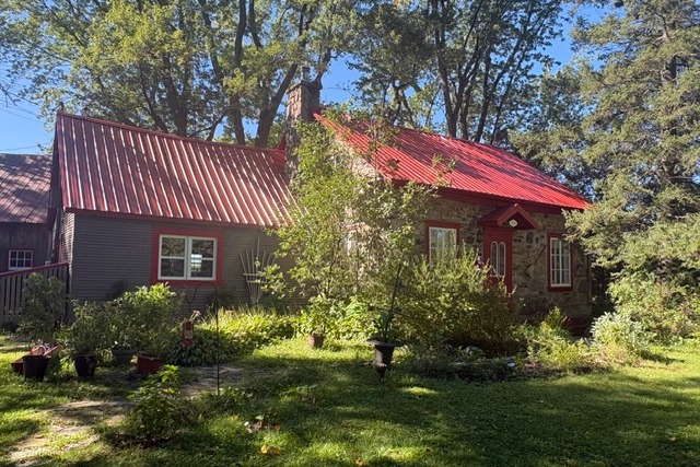Maison de pierre au toit rouge avec fenêtres neuves Touchette