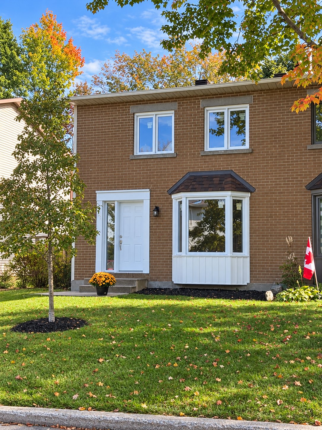 Fenêtres blanches et fenêtre en baie sur une maison en brique